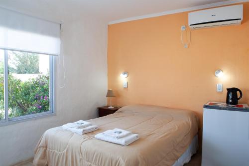 een slaapkamer met een bed met handdoeken erop bij Desert Tracks Rancho in Las Grutas