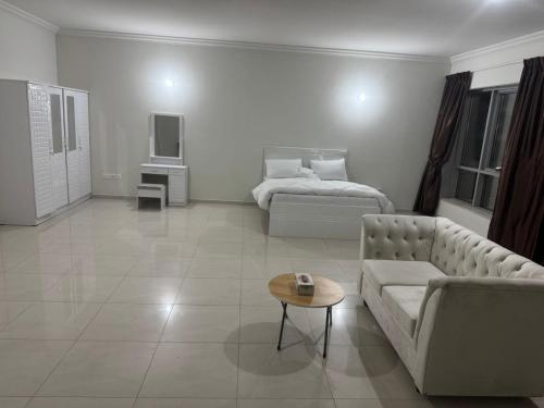 a living room with a couch and a bed at SN REAL ESTATE HOME in Abu Dhabi