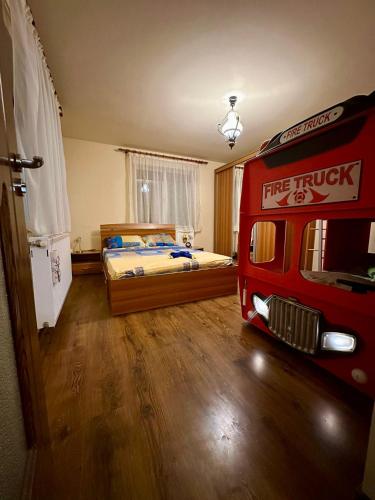 a bedroom with a bed and a red fire truck at Căsuța Tenu in Craiova