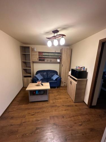 un soggiorno con un divano blu e un tavolo di Căsuța Tenu a Craiova