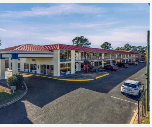 a hotel with a car parked in a parking lot at Family Inns of America - Mobile in Mobile