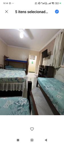 a room with two beds and a room with a tv at Cantinho e Sossego casa N 03 in Vespasiano