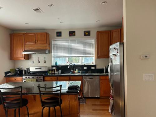 una cucina con mobili in legno e un frigorifero in acciaio inossidabile di Tranquility home a Hayward