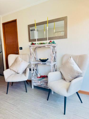 two chairs in a living room with a mirror at Departamento en Península in Iquique