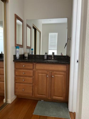 un bagno con un lavandino e un grande specchio di Tranquility home a Hayward