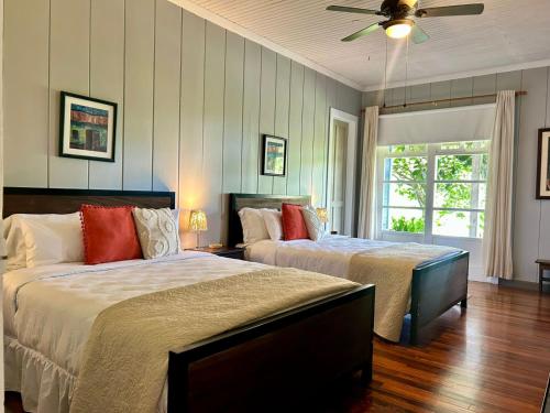 a bedroom with two beds and a ceiling fan at Casa Hacienda La Esperanza in Turrialba