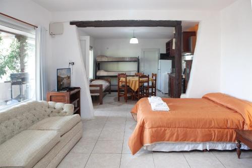 una camera da letto con un letto e un soggiorno di Desert Tracks Rancho a Las Grutas