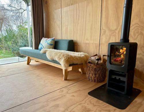 a living room with a couch and a wood stove at Lakehouses luxe family holiday house 6 pers in Oud-Ade