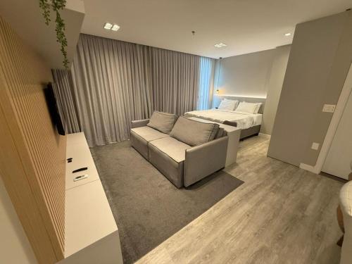 un soggiorno con un divano e un letto di JD Village a Itapema