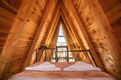 a bed in a room with a large window at Homeland Nest in Žabljak