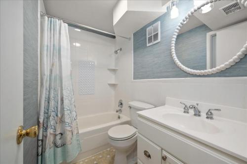 a bathroom with a toilet and a sink and a mirror at 2 Bedroom Ocean Block Condo, Steps to the Beach! in Ocean City
