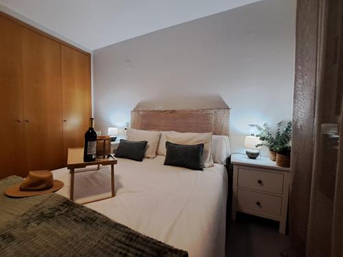 una camera con un grande letto e una bottiglia di vino di kalma a Moncófar