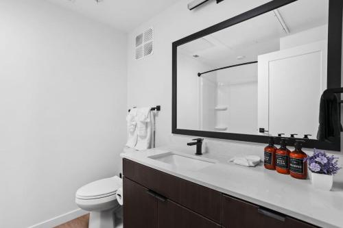 un bagno con lavandino, WC e specchio di Super LUX SkyTower 2BD Downtown - Parking, Pool, Gym a Indianapolis