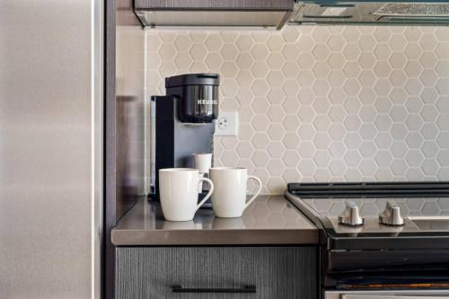 a kitchen with two coffee cups on a counter at Chic Channelside Studio | Perfect Gate Away! in Tampa