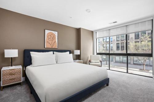 een slaapkamer met een groot bed en een groot raam bij Premier Downtown Indy Pad in Indianapolis