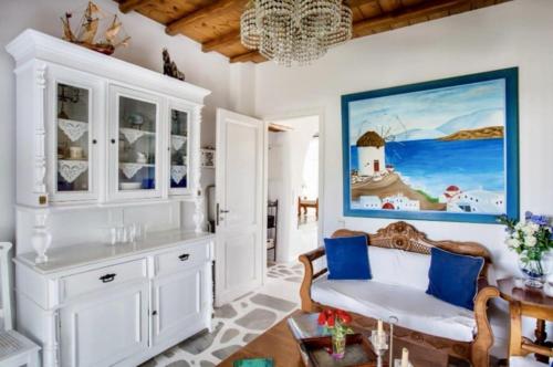 un soggiorno con mobili bianchi e accenti blu di Villa Erika ad Agios Ioannis