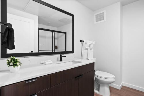 een badkamer met een wastafel, een toilet en een spiegel bij Premium Downtown High-Rise Condo with Pool, Parking, Gym in Indianapolis