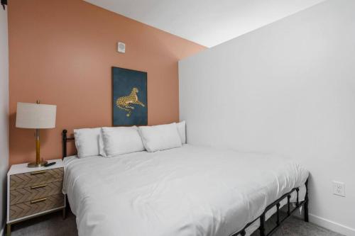 een slaapkamer met een groot wit bed en een lamp bij The Indy Suite High-Rise Condo with Pool, Gym, Parking in Indianapolis