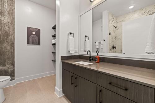 a bathroom with a sink and a toilet and a mirror at 1BR Channelside | Free Amenities + Prime Location in Tampa