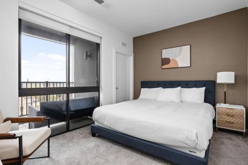 ein Schlafzimmer mit einem großen Bett und einem Balkon in der Unterkunft Downtown Indy Luxury Stay in Indianapolis