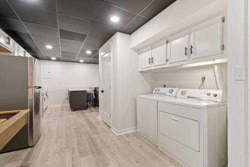 a kitchen with white cabinets and a washer and dryer at Billion Dollar Views in Winchester
