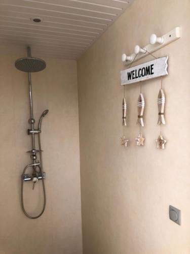 a bathroom with a shower and a welcome sign on the wall at Aqua Lodge, Les Saintes, Terre de Haut, Guadeloupe in Terre-de-Haut
