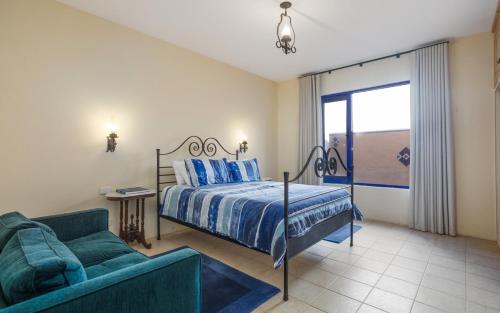 a bedroom with a bed and a couch and a window at Casita Alegre - Clifftop Stay Above Knight Beach in Port Elliot