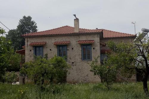 Une ancienne maison en briques avec une cheminée en haut dans l'établissement Σπίτι στο Χωριό - Les campagnards, à Rodhodháfni