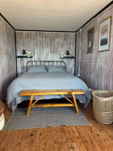 een slaapkamer met een bed en een houten tafel bij La Mar de Filomena in Tomé
