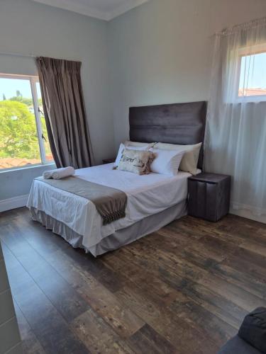 een slaapkamer met een bed en een groot raam bij Holland Manor in Durban