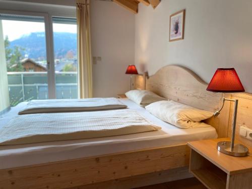 een slaapkamer met een bed met twee lampen en een raam bij 3-Raum-Maisonette-Wohnung Sonnenblume in Bolsterlang