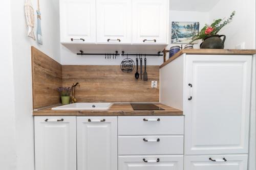 eine Küche mit weißen Schränken und einer Spüle in der Unterkunft Villa Agora - Betina in Betina