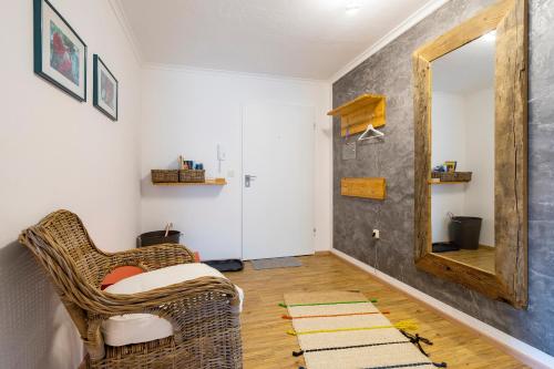 a living room with a wicker chair and a mirror at Haus Ideal 2-Raum-Wohnung Rosenrot in Fischen