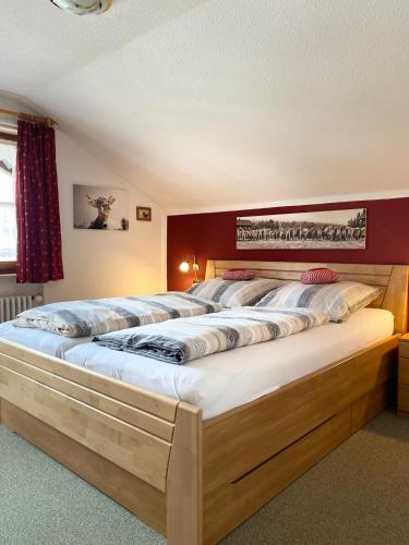 a large bed in a bedroom with avertisementatronatronstrationstrationstration at Ferienwohnung "Am Dorfbach" mit Sommer Hörnerbahnen kostenlos in Bolsterlang