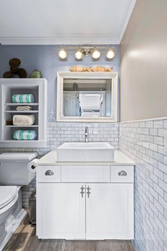 a white bathroom with a sink and a toilet at Modern Beachfront Escape - Steps from Ferry - Deck in Provincetown