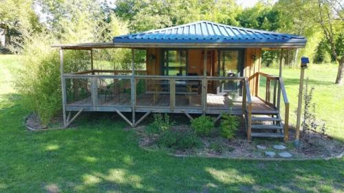 a large wooden cabin with a blue roof at ZEcamping 3 étoiles piscine chauffée in Vendoire