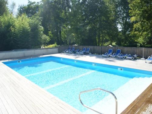 a large swimming pool with blue chairs in a yard at ZEcamping 3 étoiles piscine chauffée in Vendoire