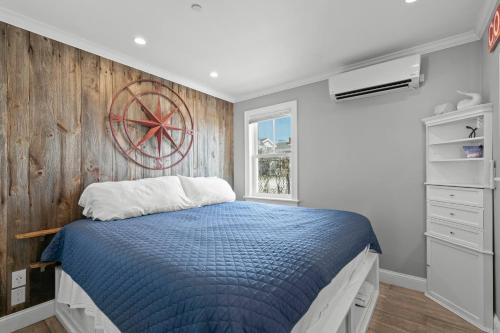 a bedroom with a blue bed and a wooden wall at Modern Beachfront Escape - Steps from Ferry - Deck in Provincetown