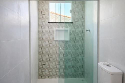 a bathroom with a shower with a toilet and a window at Casa privativa em Itaúna in Saquarema