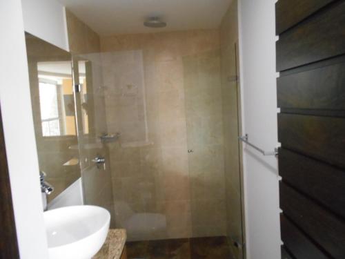 a bathroom with a shower with a sink and a toilet at Apartasuites AV in Medellín