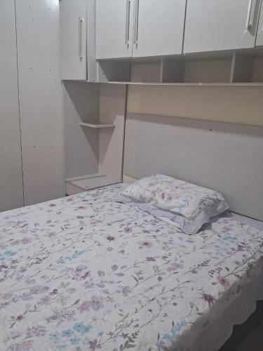 a bed in a room with an empty shelf at Casa Torres in Torres
