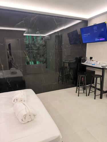 卡塔尼亚Haven Home Suite & Spa的房间里有一张白色的床和一张桌子和椅子