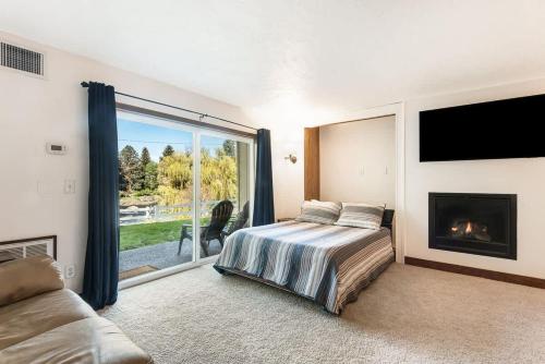 a bedroom with a bed and a fireplace at Ground Floor - Riverfront Studio in Bend