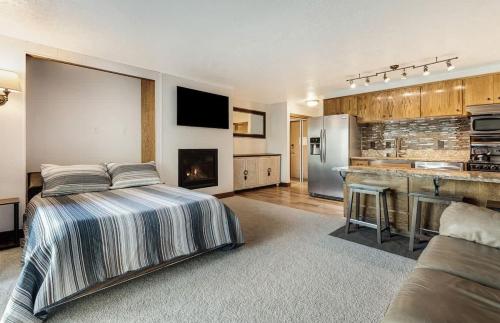 a large bedroom with a bed and a kitchen at Ground Floor - Riverfront Studio in Bend