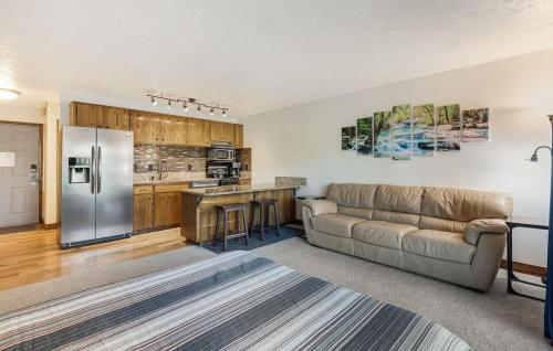 a living room with a couch and a kitchen at Ground Floor - Riverfront Studio in Bend