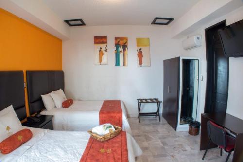 ein Hotelzimmer mit zwei Betten und einem Schreibtisch in der Unterkunft The lit 13 in Querétaro