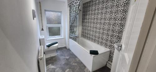 een badkamer met een bad, een toilet en een wastafel bij St Johns - 2 Bed House in Balby