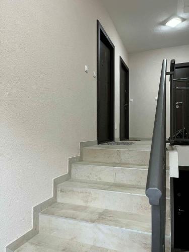 a staircase with two black doors in a house at studio apartman in Vrnjci
