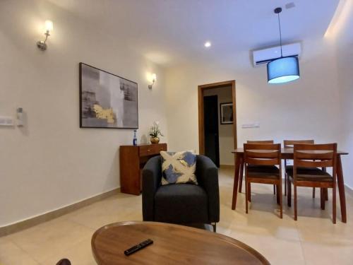 ein Wohnzimmer mit einem Stuhl und einem Esstisch in der Unterkunft Residence Helice in Kinshasa