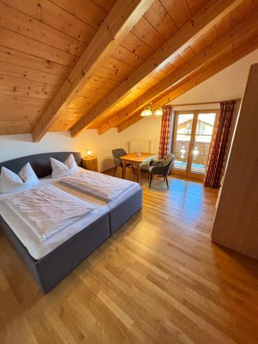 ein Schlafzimmer mit einem großen Bett und einem Holzboden in der Unterkunft Apartment Anda in Garmisch-Partenkirchen